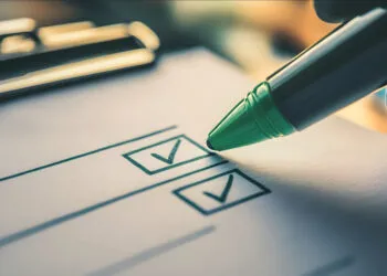 Eine Person hakt die Voraussetzungen für die OTA-Ausbildung auf einer Checkliste ab, um die persönliche Eignung zu prüfen.