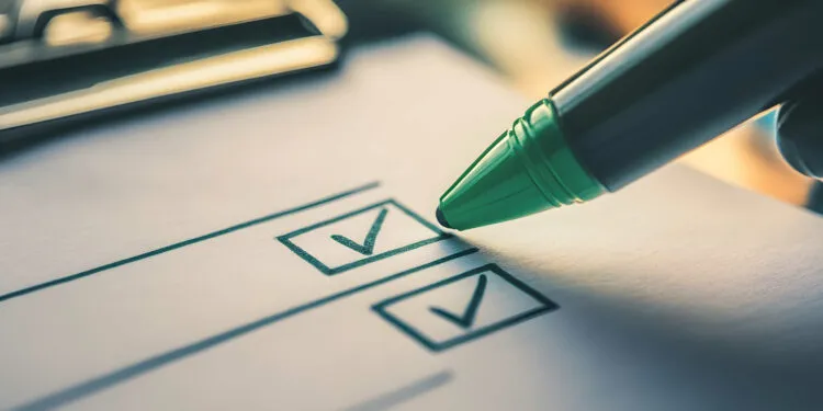 Eine Person hakt die Voraussetzungen für die OTA-Ausbildung auf einer Checkliste ab, um die persönliche Eignung zu prüfen.