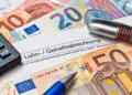 Eine österreichische Lohn- und Gehaltsabrechnung mit Euro-Scheinen symbolisiert das Gehalt in der OTA-Ausbildung und den Verdienst als diplomierte OTA.