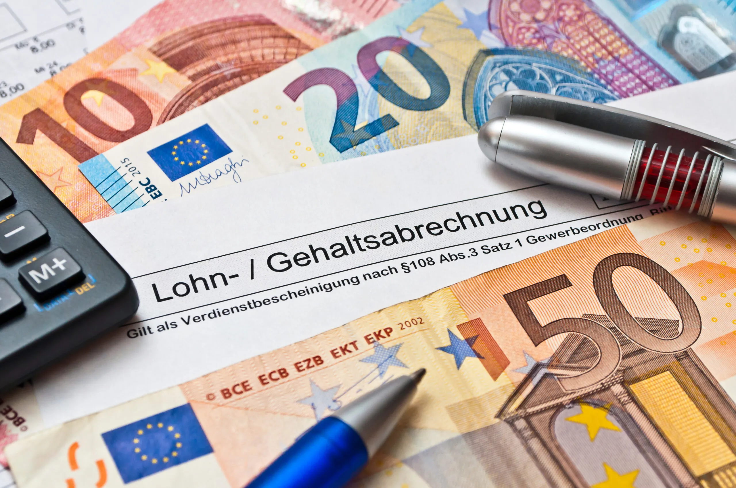 Eine österreichische Lohn- und Gehaltsabrechnung mit Euro-Scheinen symbolisiert das Gehalt in der OTA-Ausbildung und den Verdienst als diplomierte OTA.